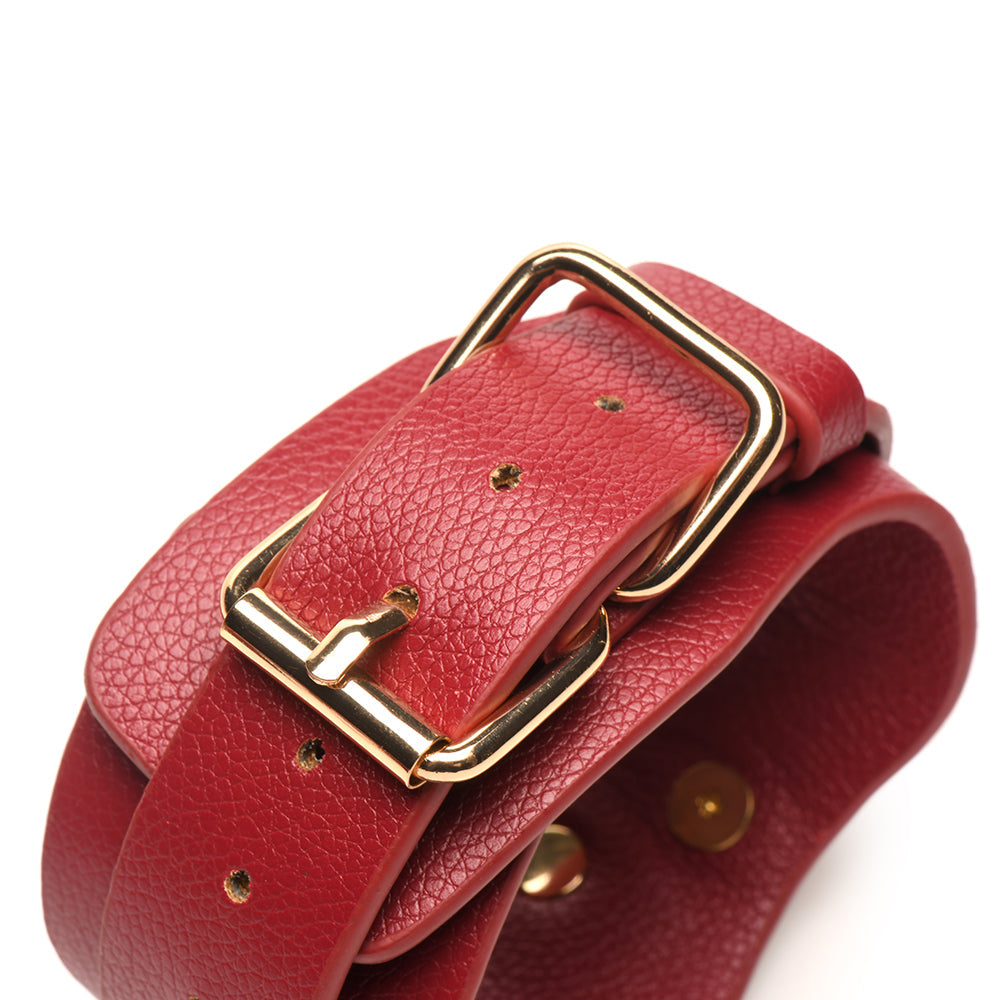 Close-up of red vegan leather wrist cuff with adjustable buckle for comfortable wear during intimate moments.