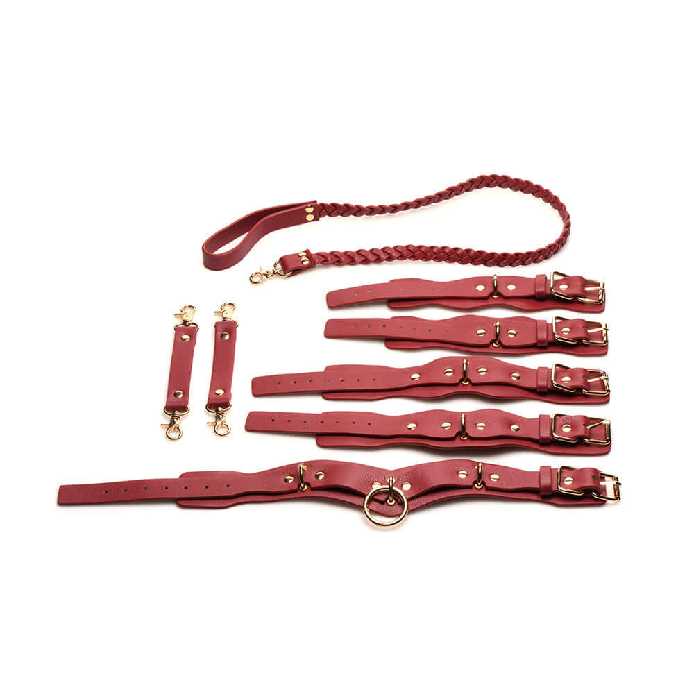 Red vegan leather restraints set with wrist cuffs, ankle cuffs, a collar, braided leash, and adjustable connectors.