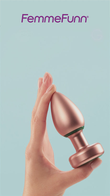 FemmeFunn Bougie Plug Rose Gold held in hand against a light blue background, showcasing its elegant design.