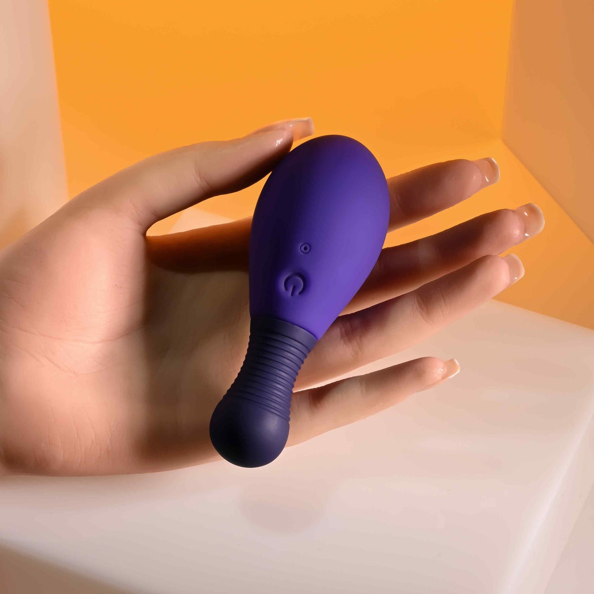Selopa Egg Me On Remote Control Egg Vibrator Purple held in a hand on a smooth surface, showcasing its sleek design.