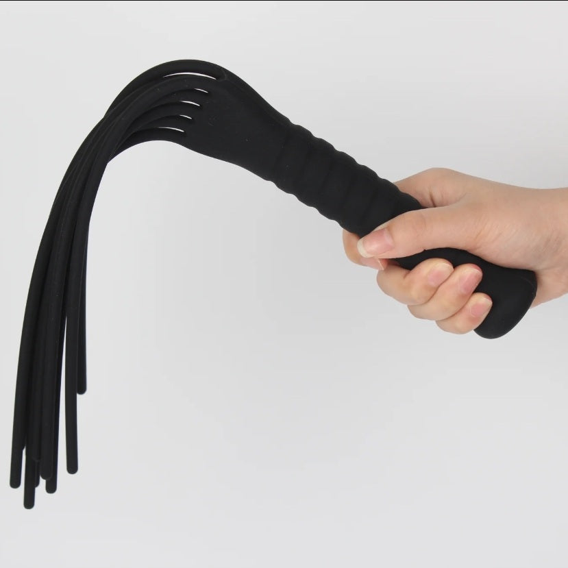 Hand holding the Fun-Mates Silea Silicone Whip Flogger, featuring an easy grip handle and flexible silicone tails.