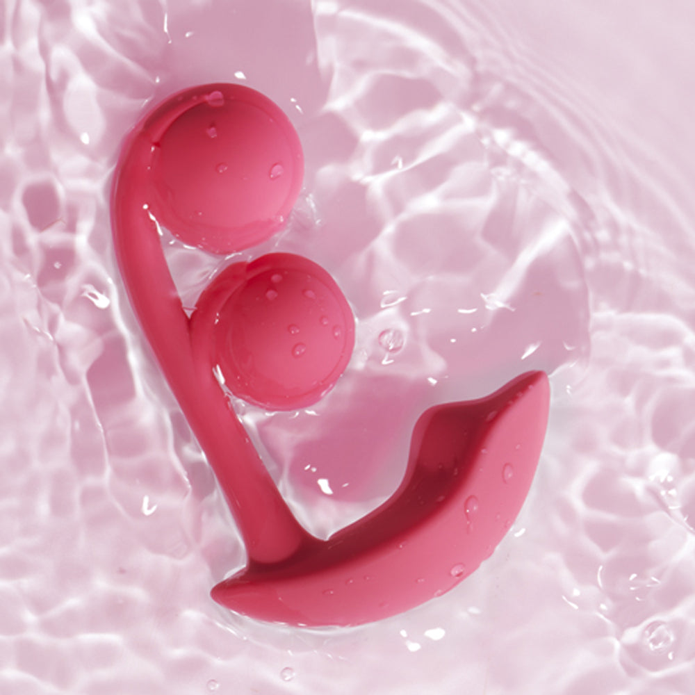 Honey Play Box Melody Wearable Dual Vibrator Pink floating in water, showcasing its unique dual-ball design.