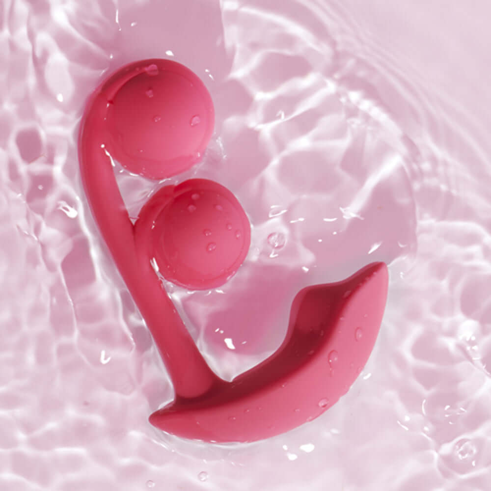 Honey Play Box Melody Wearable Dual Vibrator Pink floating in water, showcasing its unique dual-ball design.
