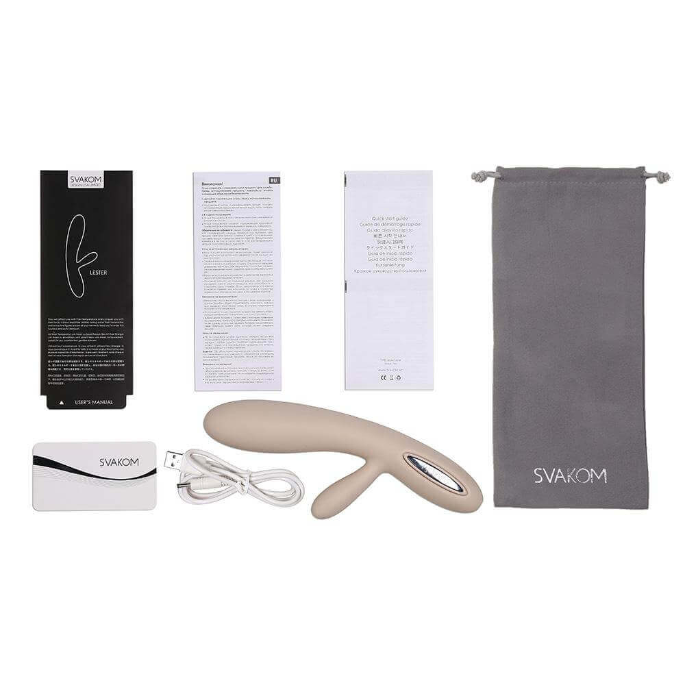 Svakom Lester Rechargeable Warming Rabbit Vibrator Khaki with packaging and accessories laid out on a surface.