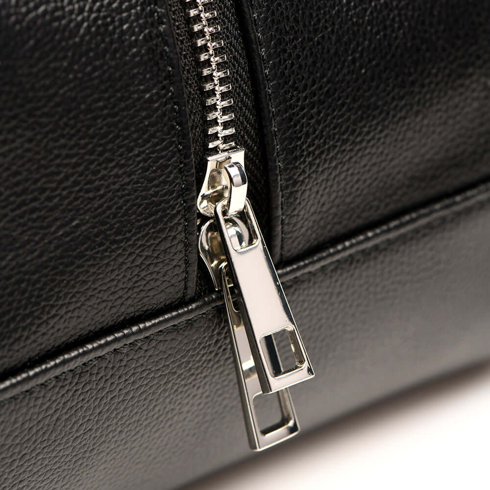 Close-up of the zipper detail on a faux leather travel bag, highlighting its durable design and silver hardware.