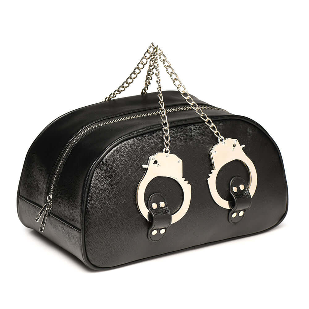 Master Series cuffed travel bag in black faux leather with handcuff handles and chain.