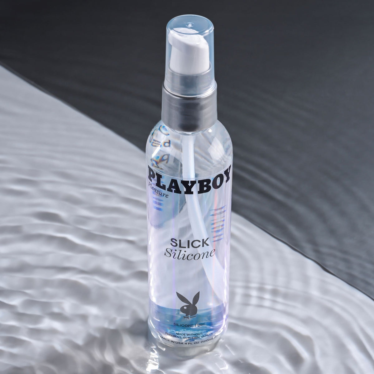 Playboy Pleasure Slick Silicone Lubricant 4 Oz bottle on a smooth surface showcasing its premium quality and design.