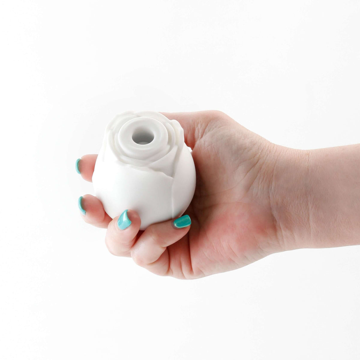 Inya the Rose Glow in the Dark Suction White held in hand, showcasing its elegant floral design and compact form.