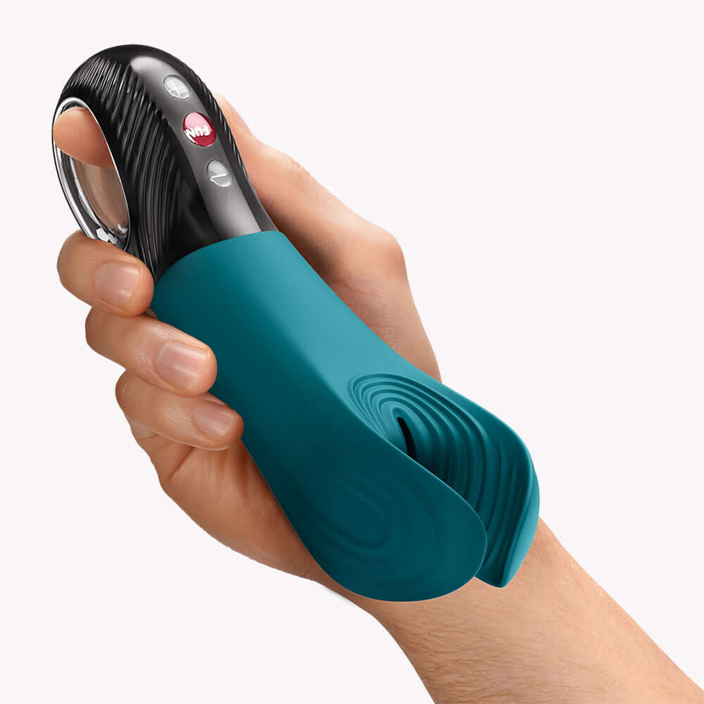 Fun Factory Manta Vibrating Masturbator Bottle Green held in hand, showcasing its unique design and flexible wings.