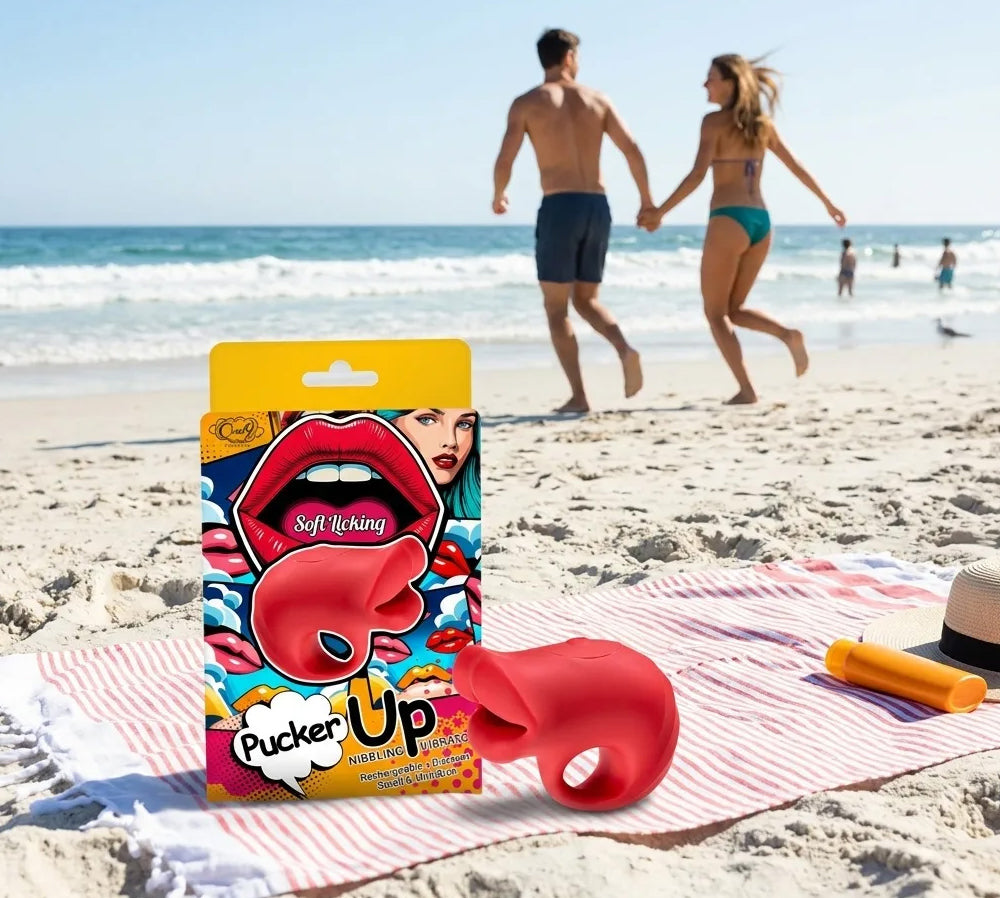 Pucker Up Lips With Ergonomic Finger Hold Red Vibrator on beach towel with couple walking in background.