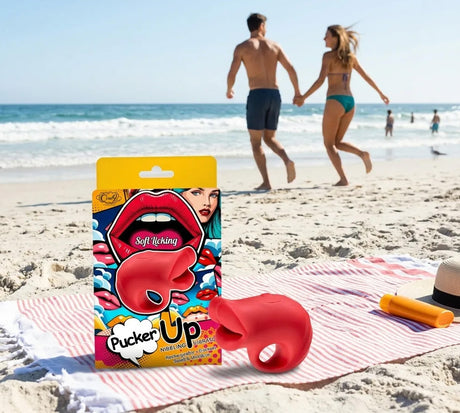 Pucker Up Lips With Ergonomic Finger Hold Red Vibrator on beach towel with couple walking in background.