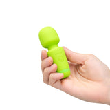 Le Wand Essentials Mini Wand Vibe Pocket-sized Vibrator held in a hand, showcasing its compact design and vibrant green color.