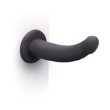 B-Vibe Essentials 7 Inch Smooth Silicone Dildo Black displayed on a white background showcasing its sleek design.