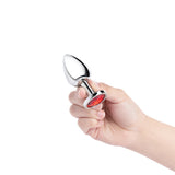 b-Vibe Essentials 3.25 Inch Steel Jewel Butt Plug Red held in hand, showcasing polished stainless steel and red jewel base.