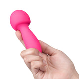 Together Spark On The Go Mini Wand Vibrator held in hand, showcasing its sleek, compact design in vibrant pink.