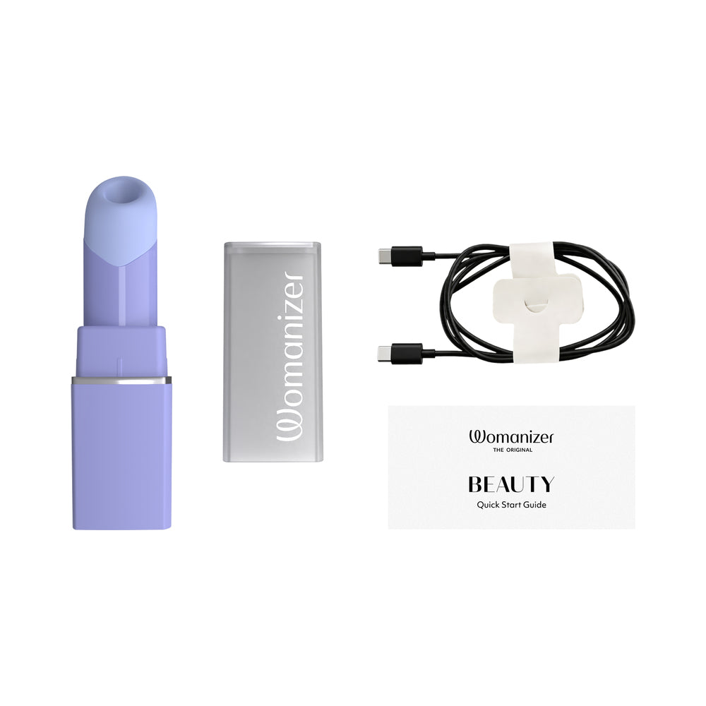 Womanizer Beauty Lilac Clitoral Air Pulse Stimulator with charging cable and quick start guide, elegantly designed in lilac.