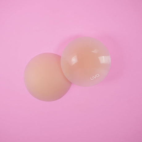 UVA Vanilla Non-Adhesive Round Nipple Covers displayed on a pink background, showcasing their seamless design.