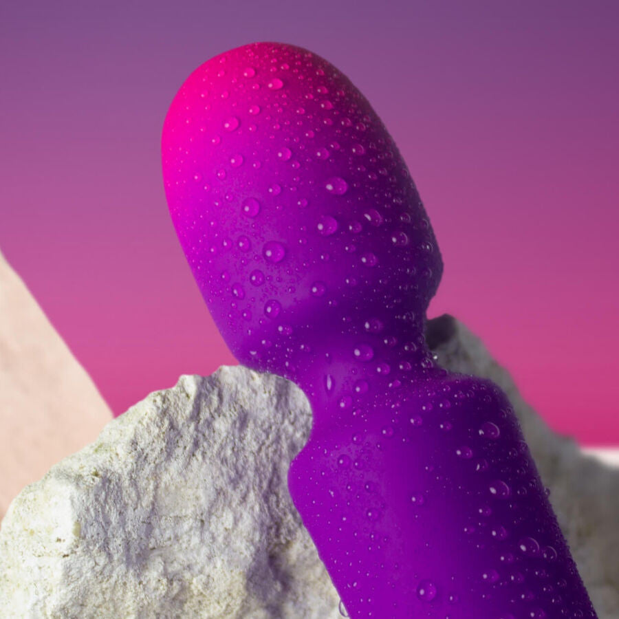 Rocks-Off Glo-Girl Mini Wand Massager Pink Purple with droplets on a stone background.
