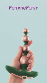 FemmeFunn Bougie Beads Rose Gold in hand against a light blue background showcasing elegant design.