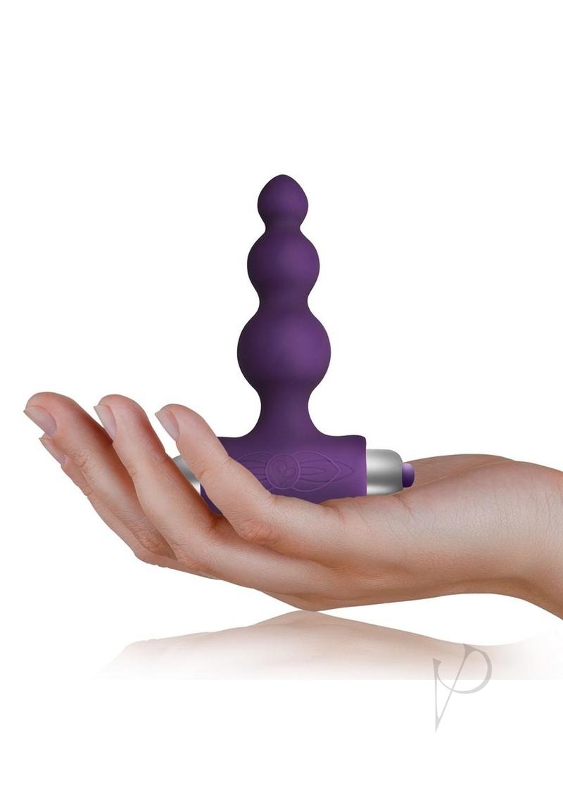 Petite Sensations Bubbles Vibrating Butt Plug Purple held in hand for size reference.