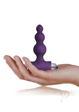 Petite Sensations Bubbles Vibrating Butt Plug Purple held in hand for size reference.