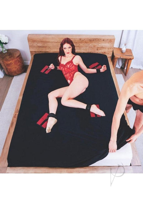 Sportsheets The Original Bondage Bed Sheet Queen Black Red used in a playful bondage scene on a bed.