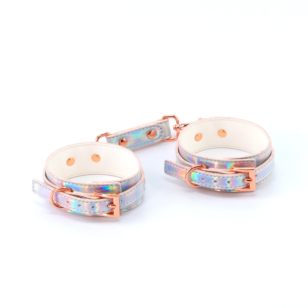 Cosmo Bondage Wrist Cuffs Rainbow showcasing a holographic shine with rose gold hardware for stylish intimate play.