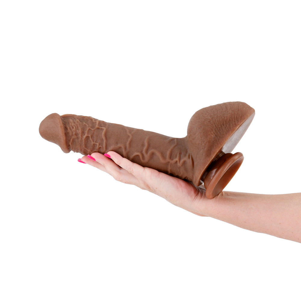 Shane Diesel Dual Density Silicone Dildo Chocolate held in hand, showcasing its lifelike design and texture.