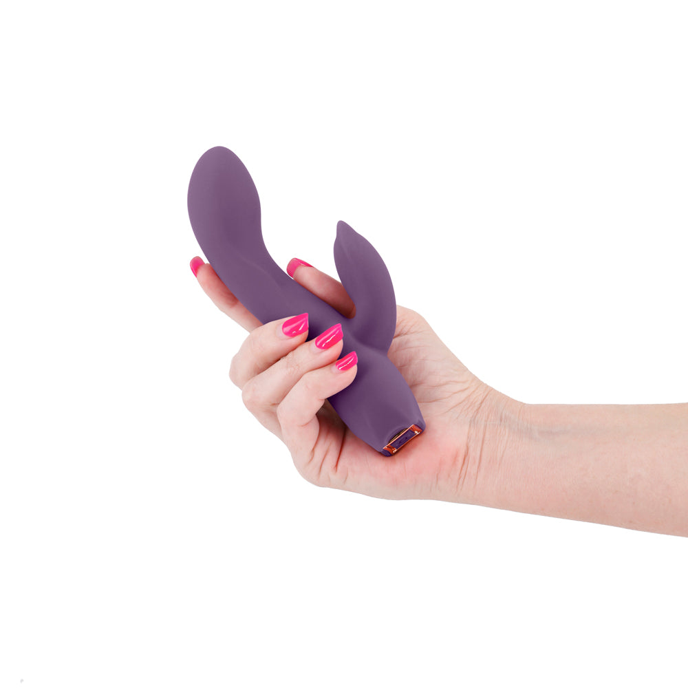 NS Novelties Obsession Juliet Rabbit Vibrator Dark Purple held in hand, showcasing its sleek design and flexible form.