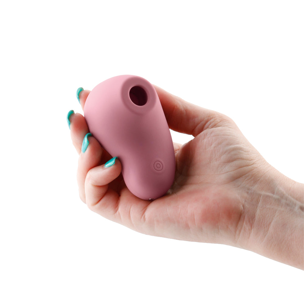 Desire Tresor Dawn Air Pulse Clitoral Stimulator held in a hand, showcasing its ergonomic design and gentle air pulse feature.