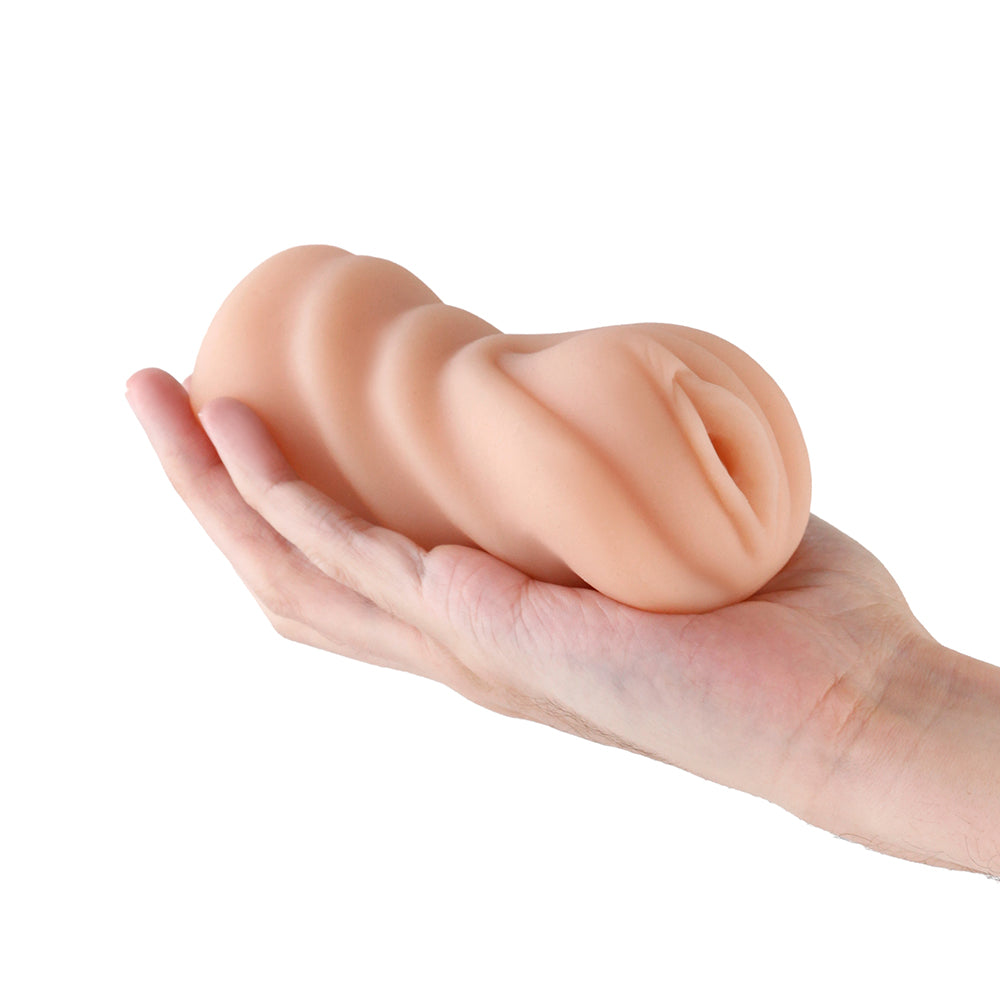 Barely Legal Carrie Stroker Closed End Masturbator Caramel held in a hand, showcasing its soft, stretchy design.