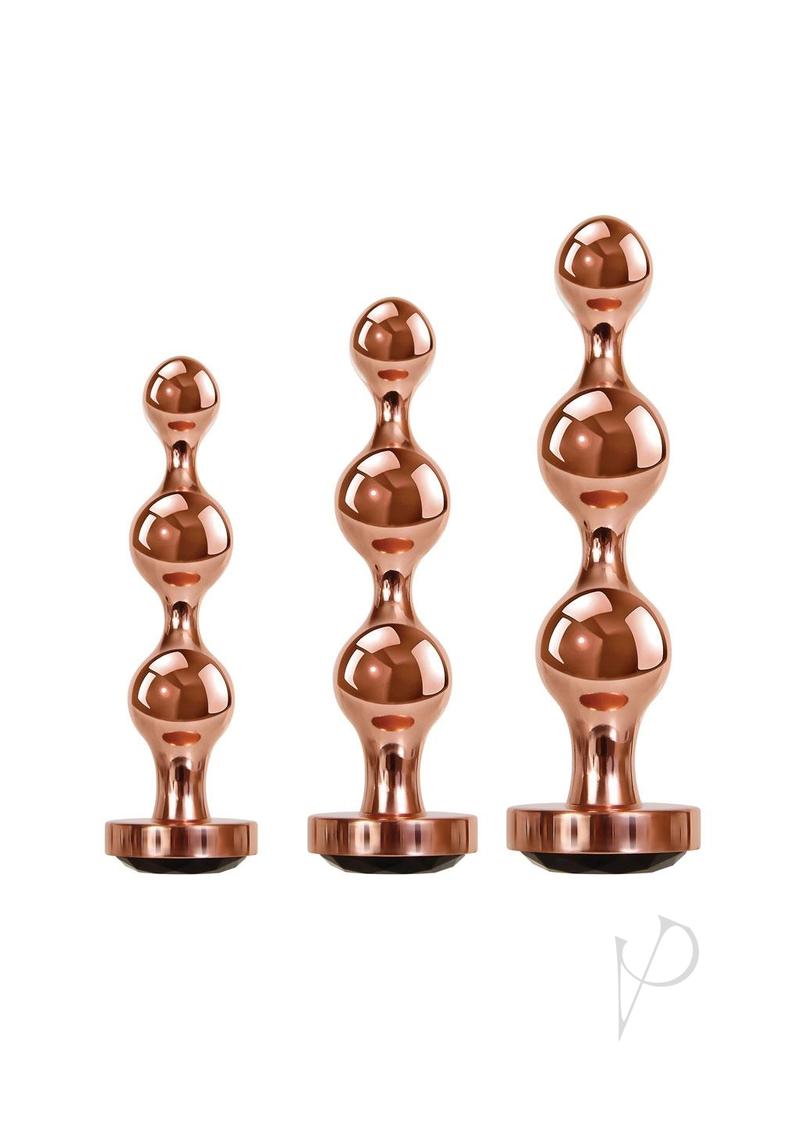 Gender X Gold Digger 3 Piece Anal Plug Set Rose Gold featuring sleek, sculptural metal plugs in rose gold finish.