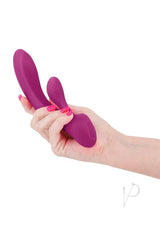 Hand holding the Obsessions Bonnie Rechargeable Silicone Rabbit Vibrator in magenta color.
