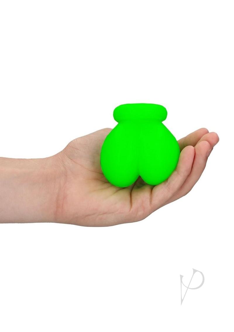 Ouch Ball Sack Glow in the Dark Green held in a hand, showcasing its vibrant fluorescent design.