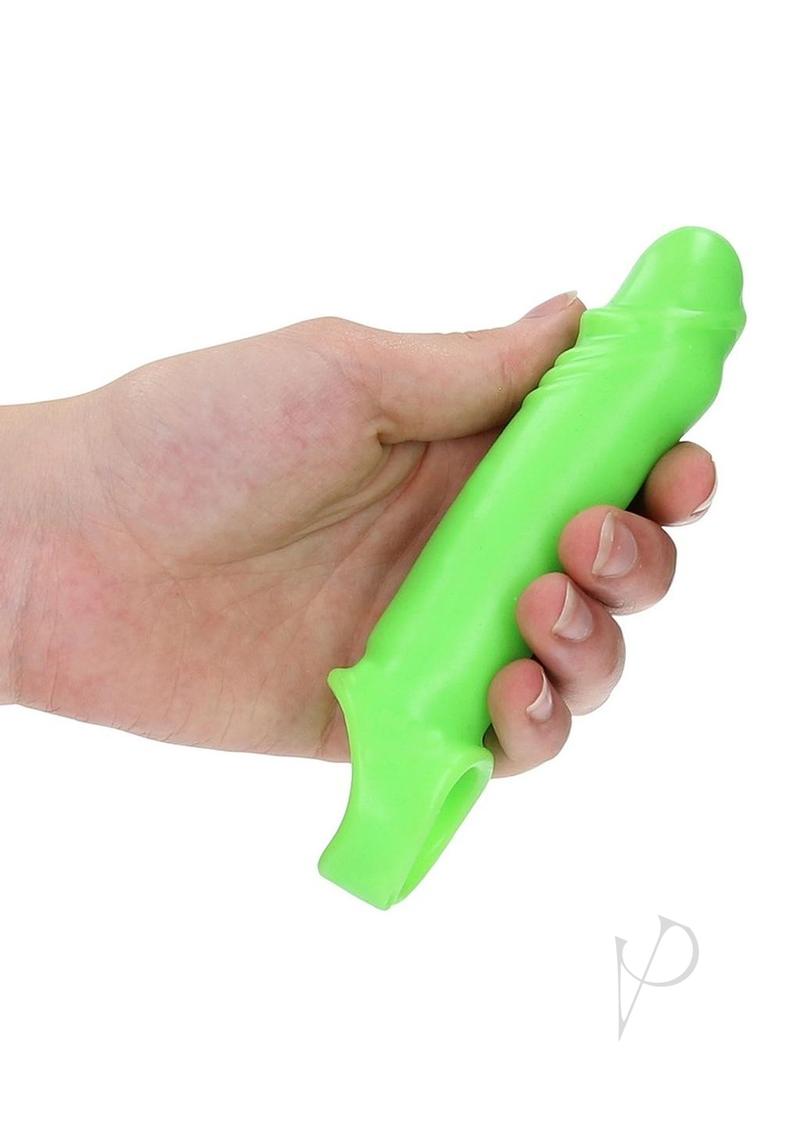 Ouch Smooth Stretchy Penis Sleeve Glow in the Dark Green held in hand, showcasing its vibrant fluorescent color.