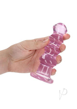 RealRock Curvy Dildo or Butt Plug 5.5 inch Pink held in hand, showcasing its smooth, curved design for pleasure.