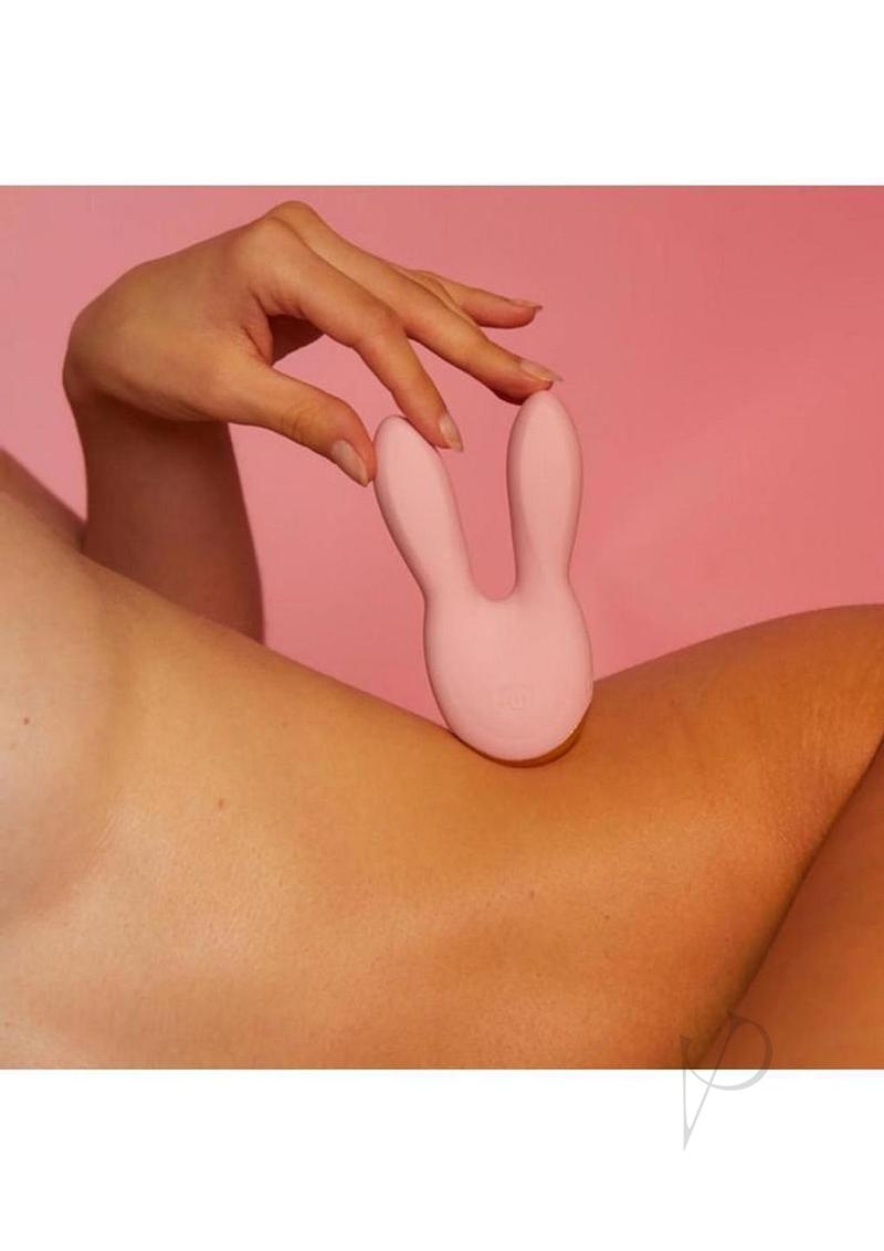Hear Me Baby Silicone Clitoral Stimulator Baby Pink nestled on a woman's arm against a pink background.