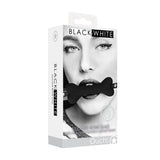 Ouch Silicone Bone Gag with Bonded Leather Straps packaging featuring a model using the gag for playful restraint.