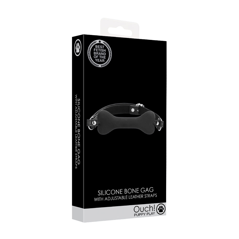 Ouch Puppy Play Silicone Bone Gag Black packaging showcasing adjustable leather straps and a silicone gag in a dog bone shape.