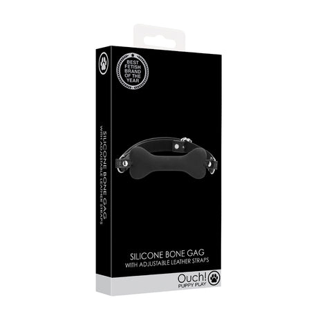 Ouch Puppy Play Silicone Bone Gag Black packaging showcasing adjustable leather straps and a silicone gag in a dog bone shape.