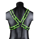 Ouch Cross Harness Glow In The Dark L XL displayed on a model's back, featuring vibrant fluorescent green detailing.