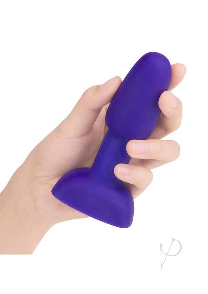 B-Vibe Rimming Petite Remote Control Anal Plug Purple held in hand showcasing its design and compact size.