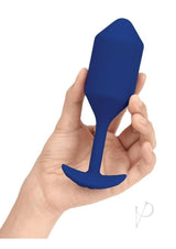 B-Vibe Vibrating Snug Plug 4 Silicone Anal Plug Navy held in hand, showcasing its sleek design and vibrant color.
