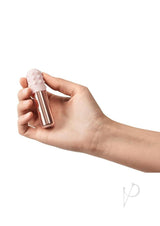 Le Wand Bullet Silicone Sleeve Vibrator Rose Gold held in hand, showcasing its compact and elegant design.