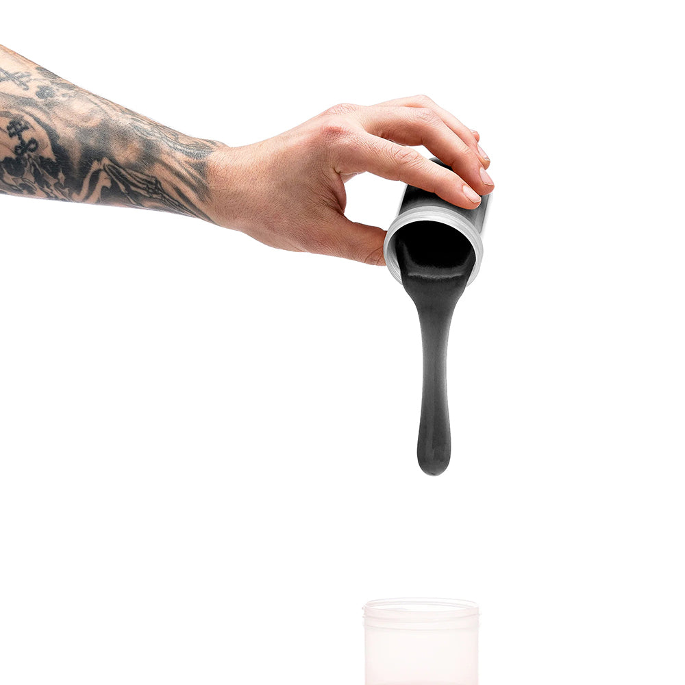 A hand pouring black silicone from a container, demonstrating usage of Clone-a-willy Silicone Refill Jet Black.
