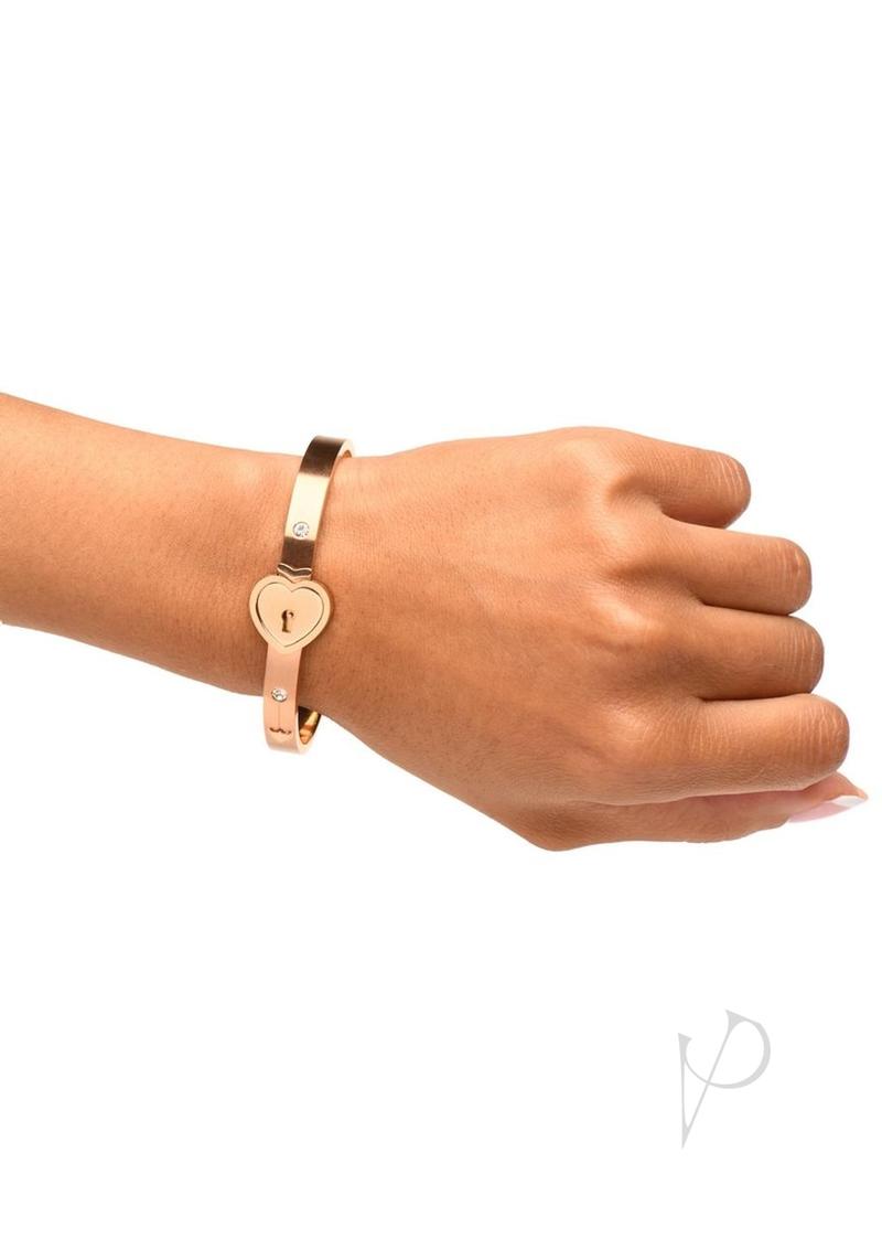 Master Series Locking Bracelet and Key Necklace Rose Gold worn on a hand, featuring heart-shaped lock and elegant design.