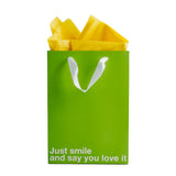 Just Smile & Say You Love It Color Gift Bag Green with yellow tissue paper inside.