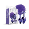 NIXIE Metal Butt Plug Set Pom Pom & Jewel-Inlaid Purple displayed with a fluffy purple pom pom and polished stainless steel plugs.