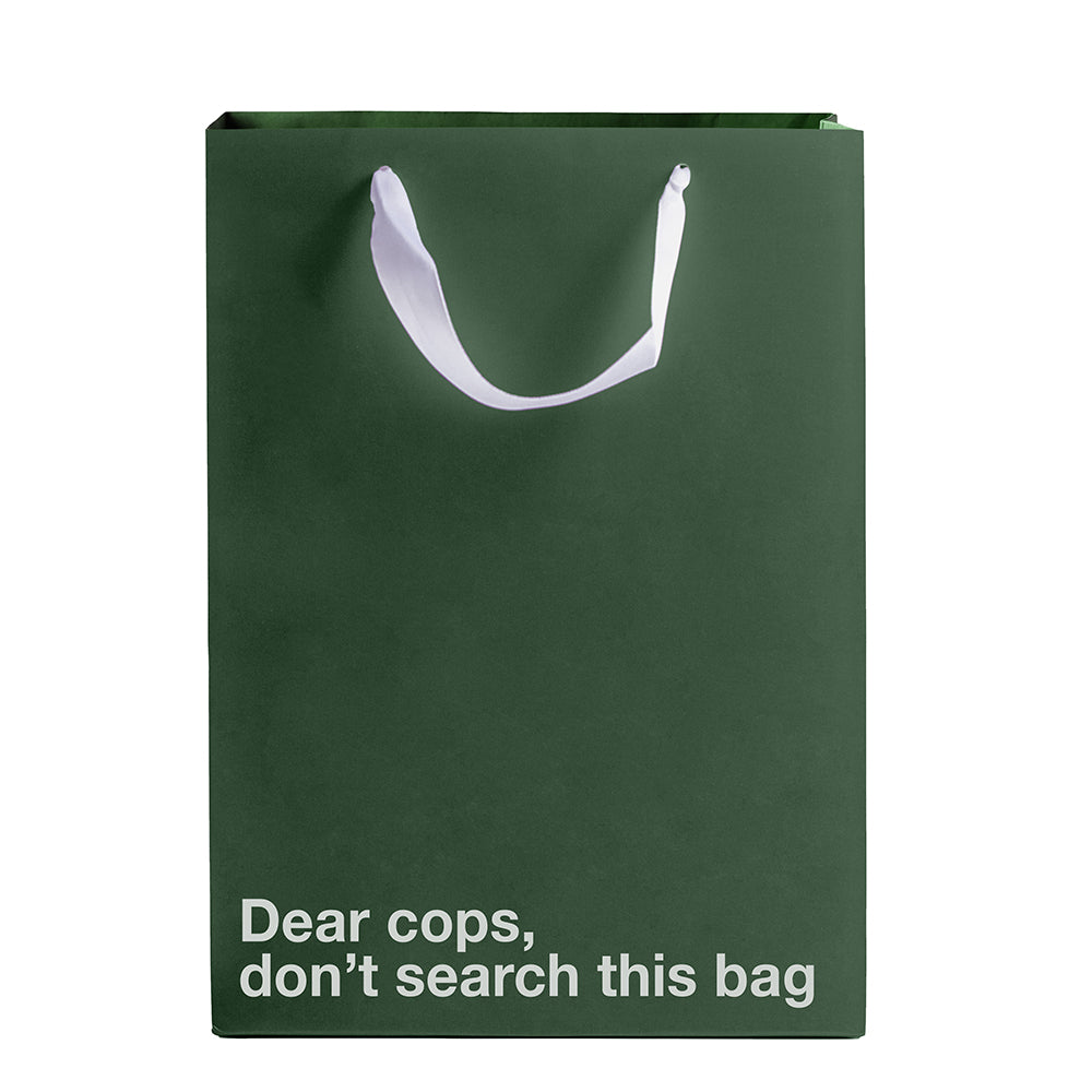 Dear Cops Don't Search This Gift Bag displayed in green Kraft paper with a white ribbon handle.
