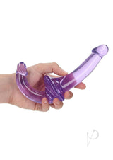 RealRock Crystal Clear Strapless Strap On 6 inch Purple held in hand, showcasing its unique design for shared pleasure.